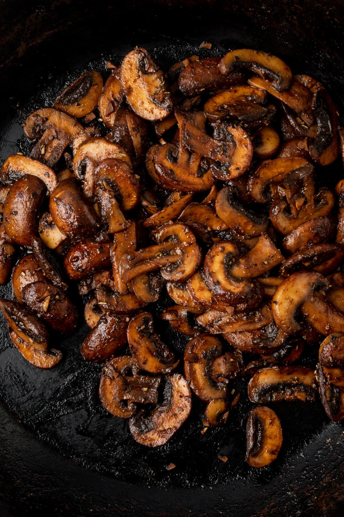 Dark, shiny sauteed sliced mushrooms coated in herbs and spices.